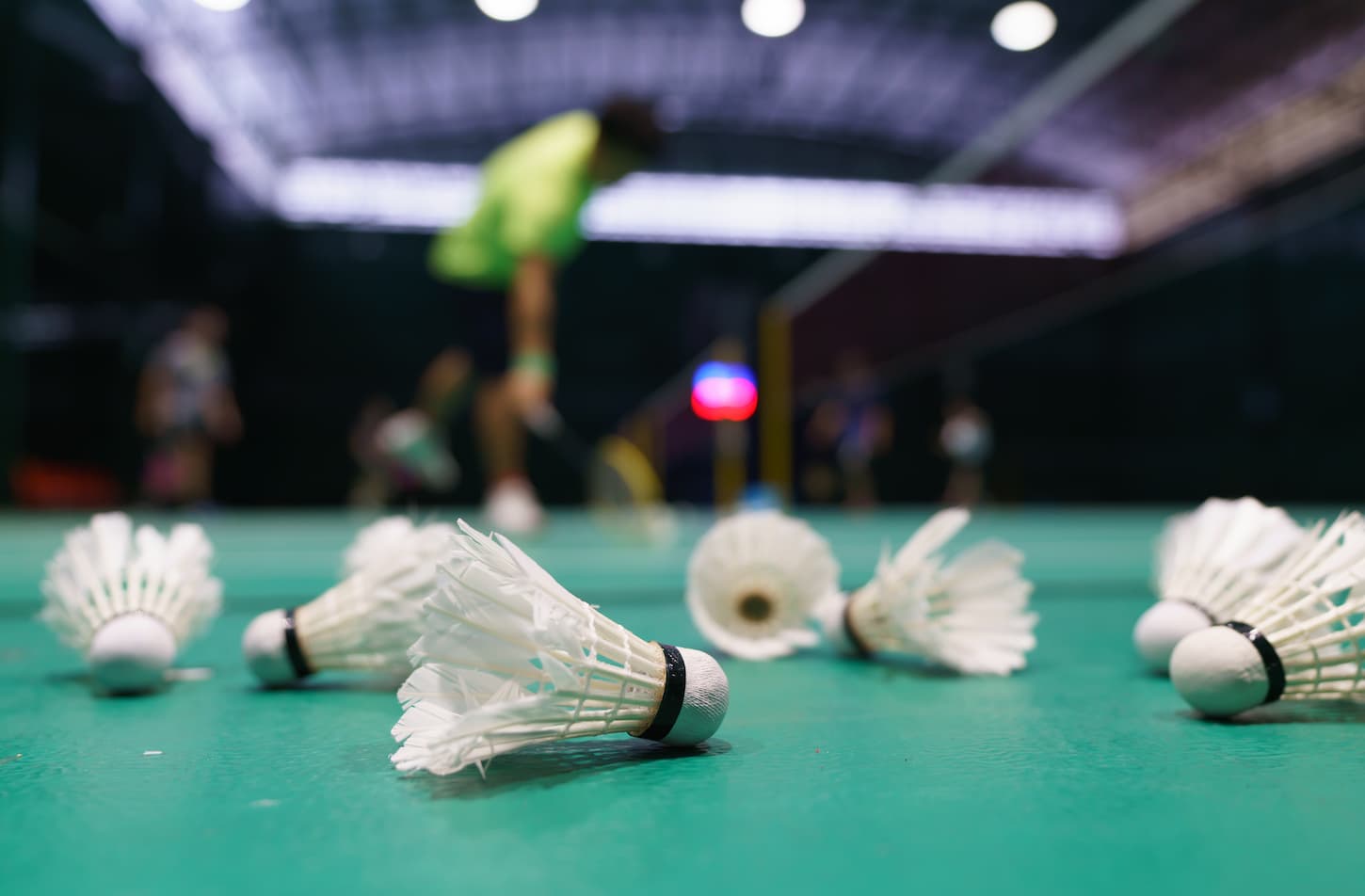 An image of shuttlecocks on a green badminton playing court.