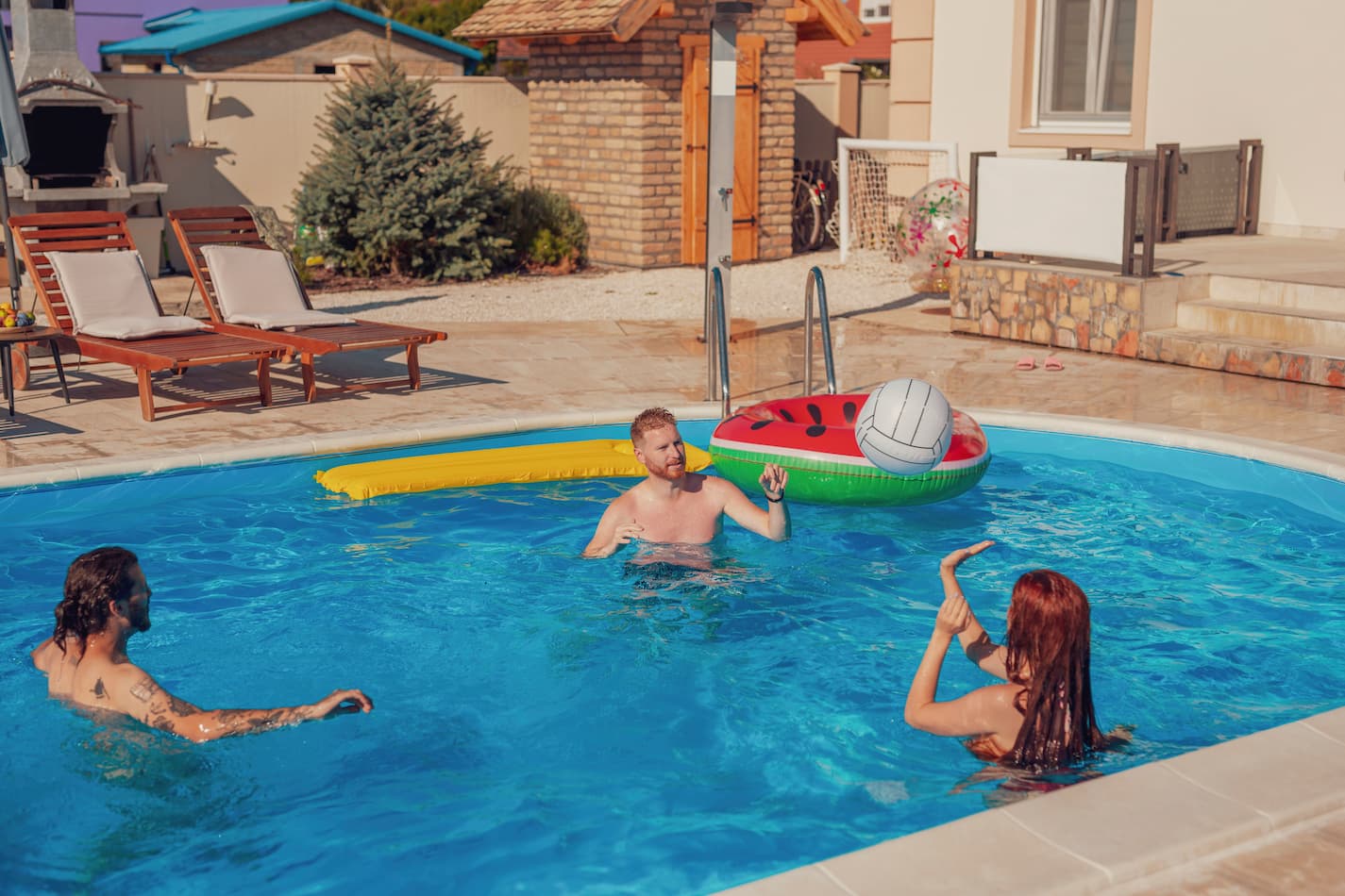 An image of friends playing volleyball at the swimming pool.