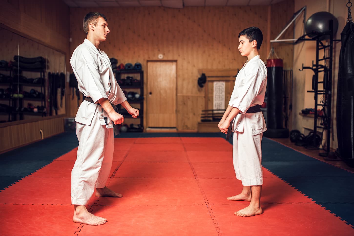 An image of a Karate master and a young disciple in white uniform in training.
