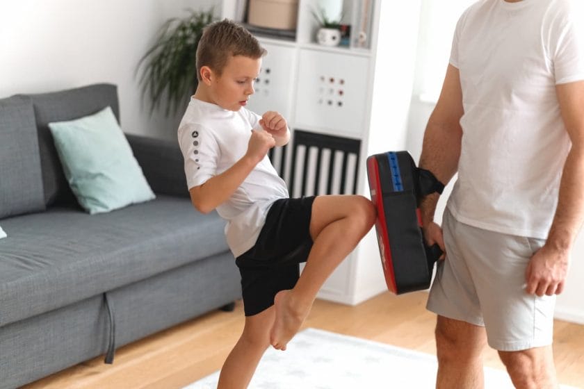 An image of a young boy training with his father, in martial arts, taekwondo. Dad and son.