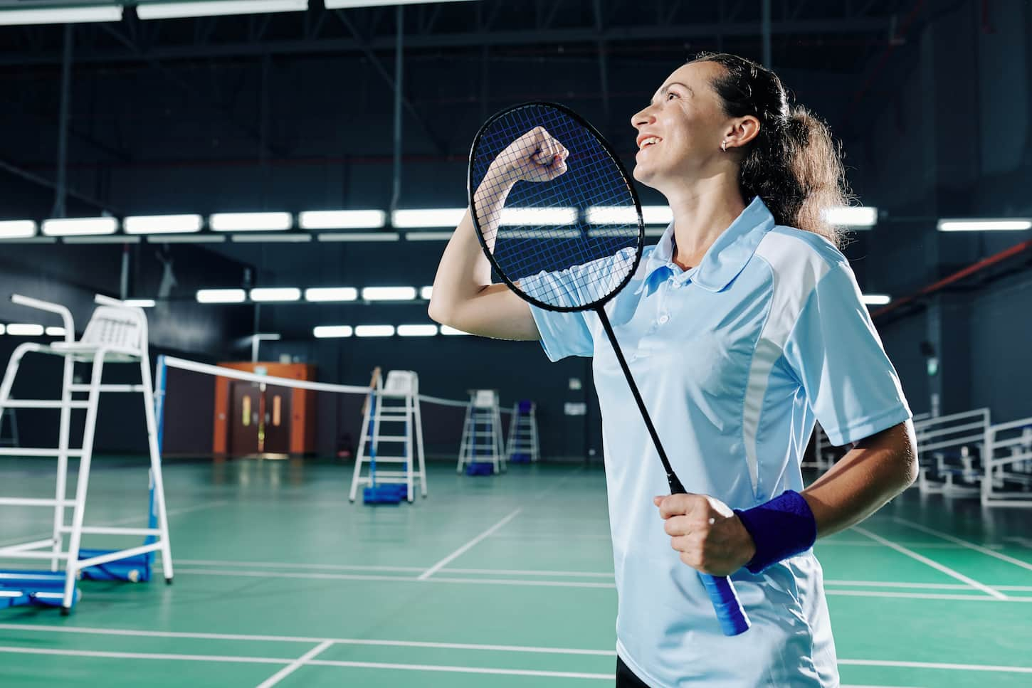 An image of an Excited happy young female badminton player making a fist bump when celebrating victory.