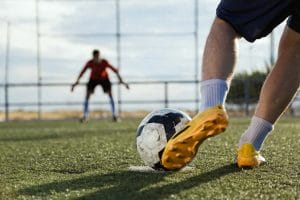 An image of a Soccer player kicking a ball.