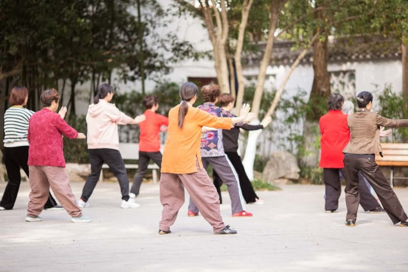 An image of Mature senior people of Asia exercising martial arts outdoors in the public park on a sunny spring day.