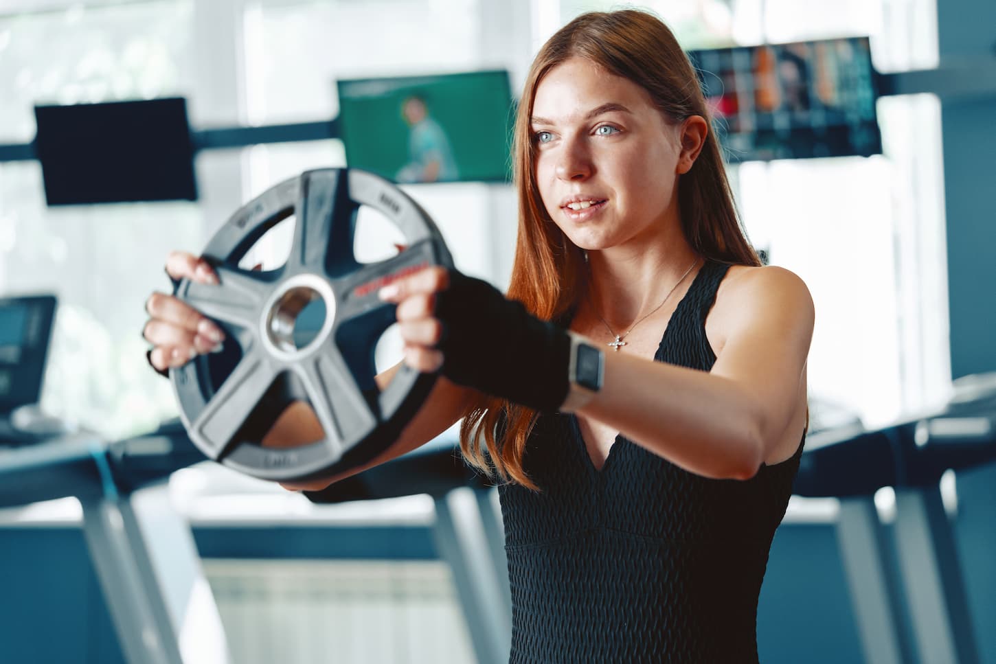 An image of a Smiling teen girl training in a fitness club, close up.