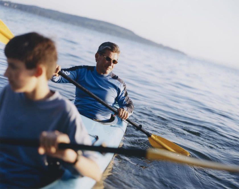 An image of a Father and son paddling a sea kayak.