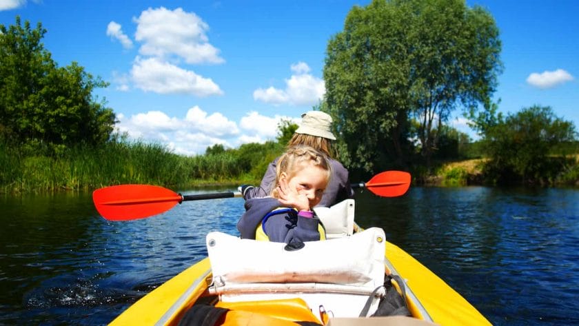 An image of a Kayaking activity with a kid on the river.
