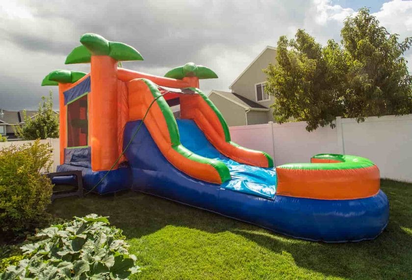 An image of an Inflatable bounce house water slide in the backyard.