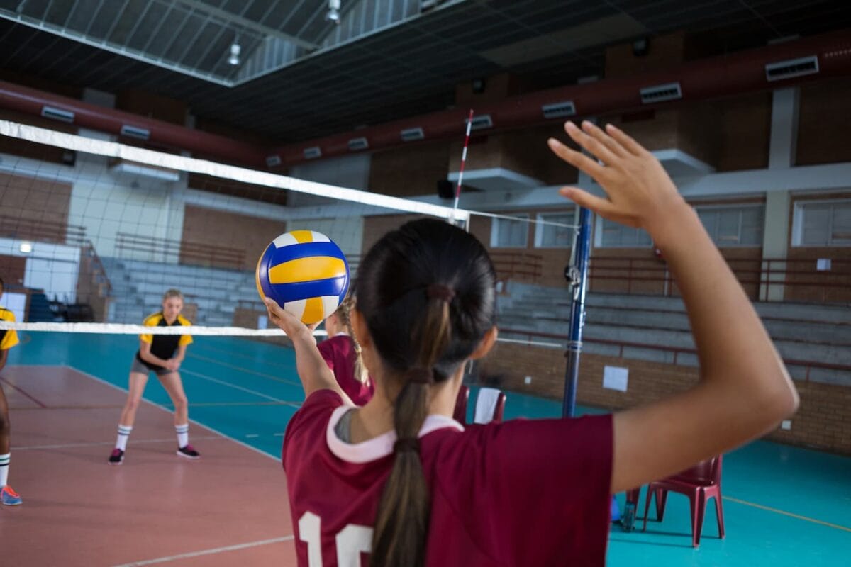 An image of Female volleyball players playing volleyball on the court.